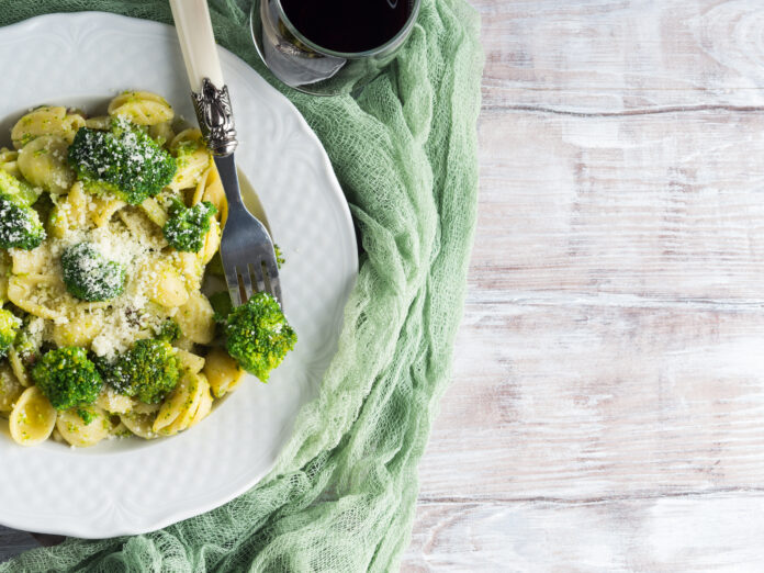 Prato de massa italiana vegana com brócolis e parmesão vegano.