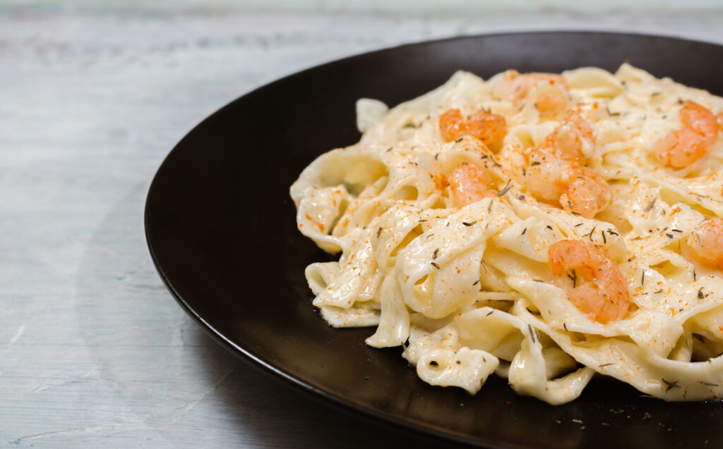 Fettuccine Alfredo cremoso com camarão e ervas