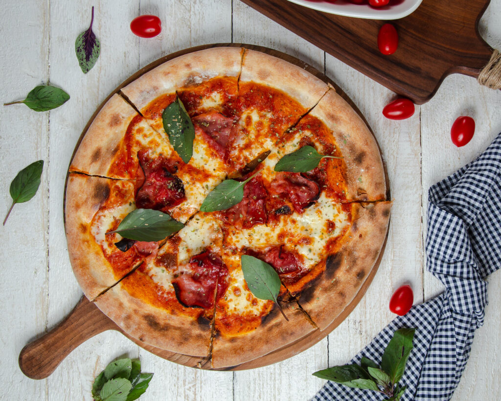 Pizza napolitana com presunto, mussarela e folhas de manjericão