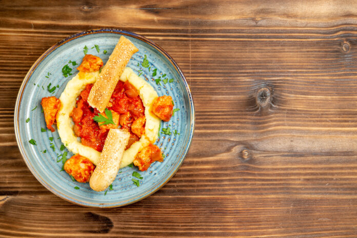 Prato italiano de polenta com frutos do mar e pão, servido em prato rústico.