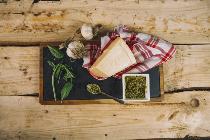 Ingredientes típicos da culinária do Valle d'Aosta, incluindo queijo, alho, manjericão e molho pesto.